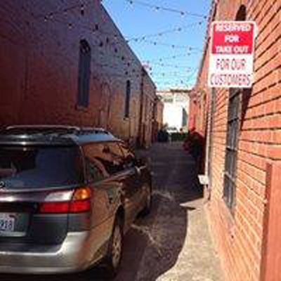a car parked by a sign that says reserved for take out