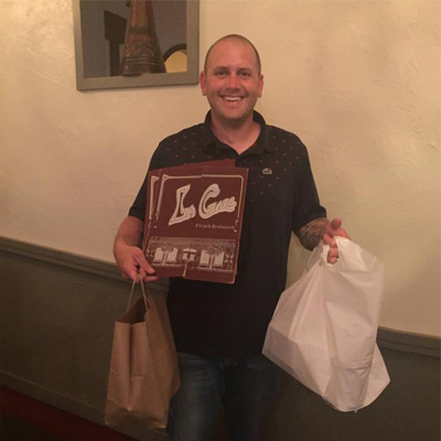 take out delivery guy holding food and menus smiling